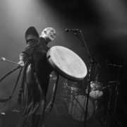 Black & white photo of Eivør holding a big pale framedrum and drumstick